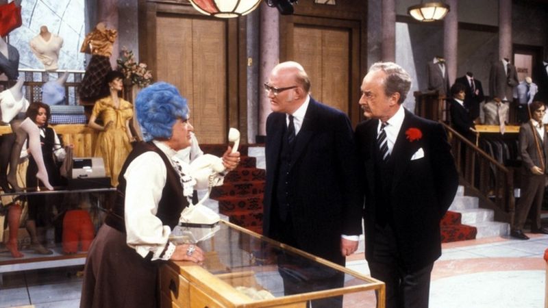 Mollie Sugden as Mrs Slocombe, Nicholas Smith as store manager Mr Rumbold, and Frank Thornton as Captain Peacock