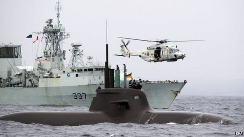 German Navy submarine U33 (front), Canadian Navy's HMCS Fredericton (left) and a Dutch helicopter (right) participate in NATO's Dynamic Mongoose anti-submarine exercise in the North Sea