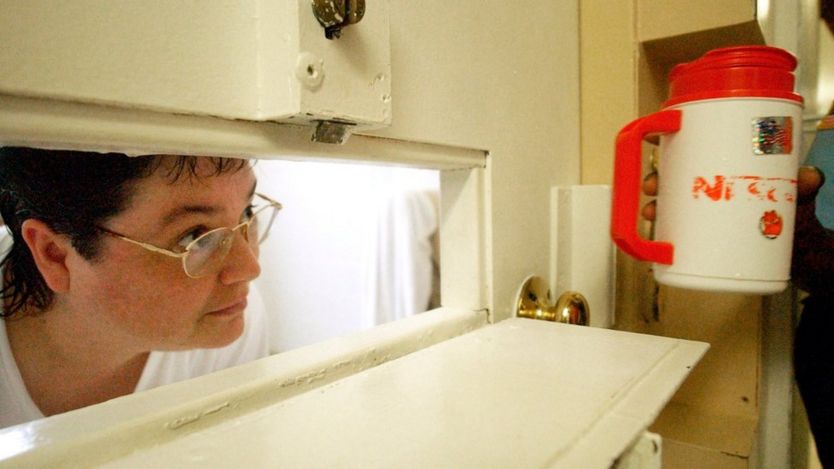 Kelly Gissendaner looks through the slot in her cell door as a guard brings her a cup of ice.