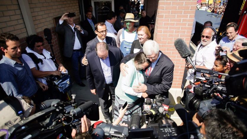 Rowan County clerk Kim Davis, center, hugs her attorney, Mat Staver, with Republican presidential candidate Mike Huckabee, centre left, next to her after being released from the Carter County Detention Center, 8 September in Grayson, Ky.