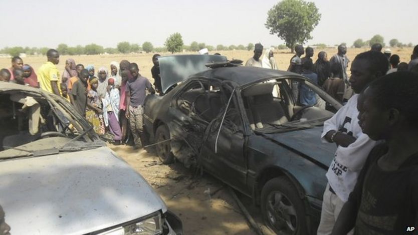 People gathered at the site of a suicide bomb attack at a car park of the College of Administrative and Business Studies in Potiskum Nigeria Friday, May 8