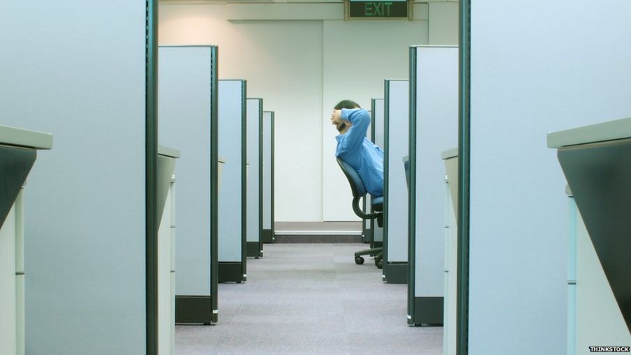 Man leans back in cubicle