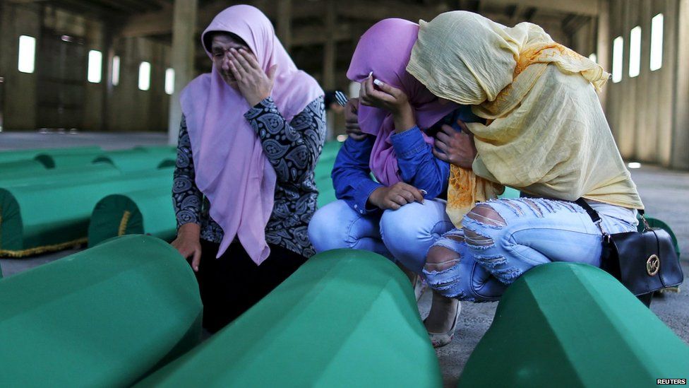 Women cry next to coffins of their relatives who were victims of the 1995 Srebrenica massacre, at the Memorial Centre in Potocari, Bosnia and Herzegovina, July 10, 2015.