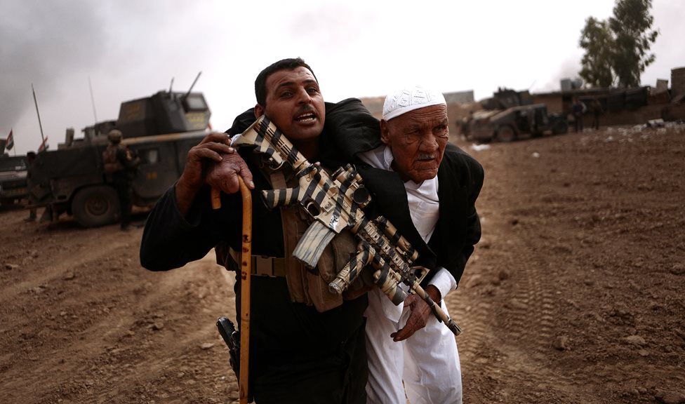 Member of Counter-Terrorism Service carries an elderly civilian to safety during a firefight in Tob Zwaya (24 October 2016)