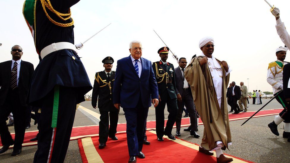Sudan President Omar al-Bashir (in brown robe) welcomes the President of the Palestinian National Authority Mahmoud Abbas (in suit) to Khartoum Airport in Sudan -19 July 2016