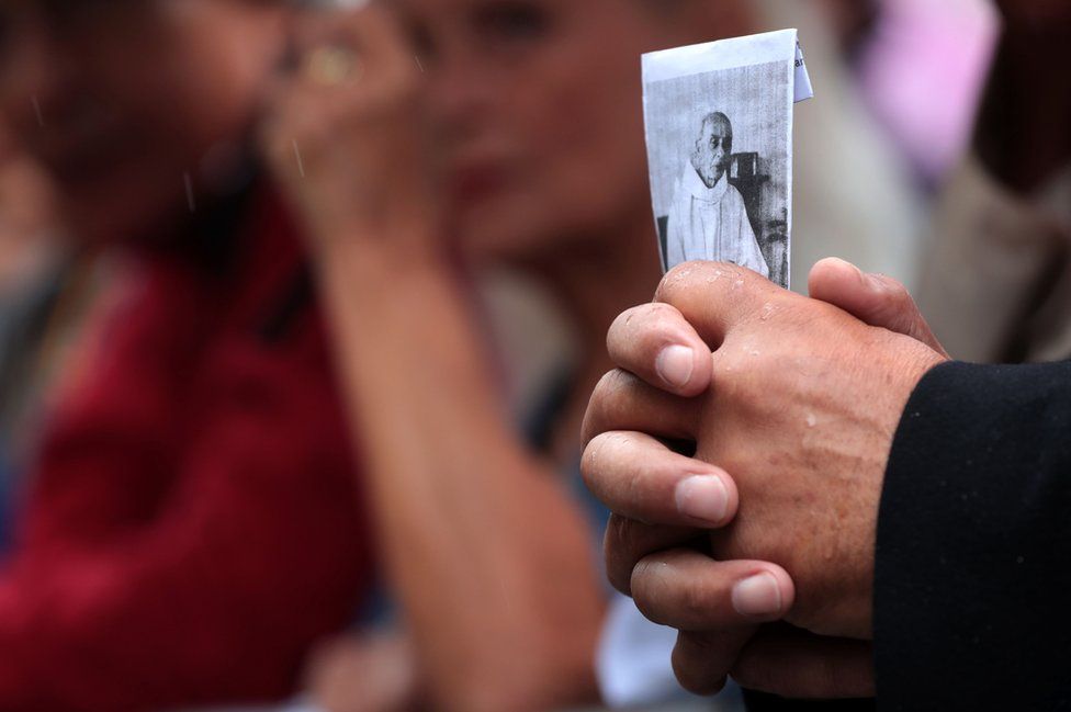 A man holds a picture of the priest Jacques Hamel outside Rouen's cathedral