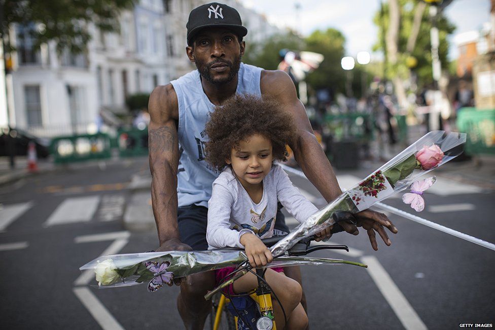 A nearby resident and his daughter bring flowers on a bike