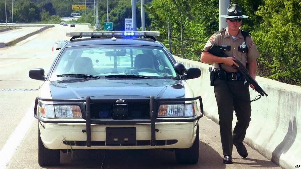 A Tennessee police officer on patrol on the Amnicola Highway after a shooting near the Naval Reserve Center in Chattanooga - 16 July 2015