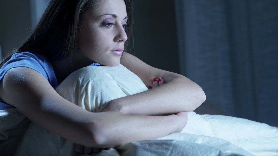 A woman sitting on her bed