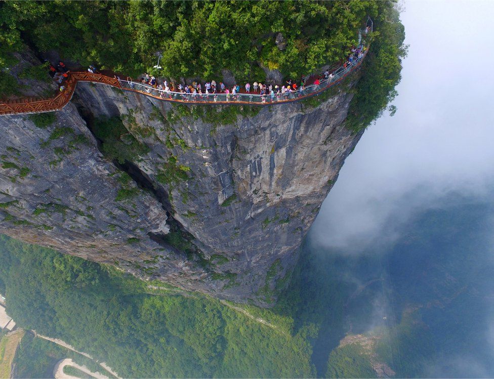 Watu wakitembea kwenye daraja la vioo la Zhangjiajie, katika mkoa wa Hunan , China, tarehe 1 Agostu, 2016.