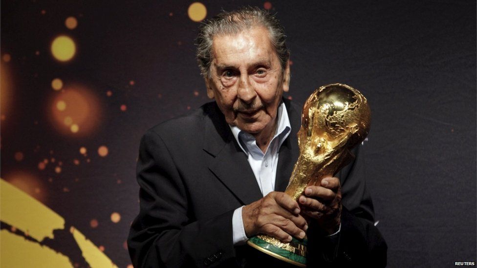 Former Uruguayan soccer player Alcides Ghiggia, famed for his role in the final 1950 World Cup match between Uruguay and Brazil, poses with the Fifa World Cup trophy during the 2014 FIFA World Cup Trophy Tour in Montevideo in this January 16, 2014 file picture