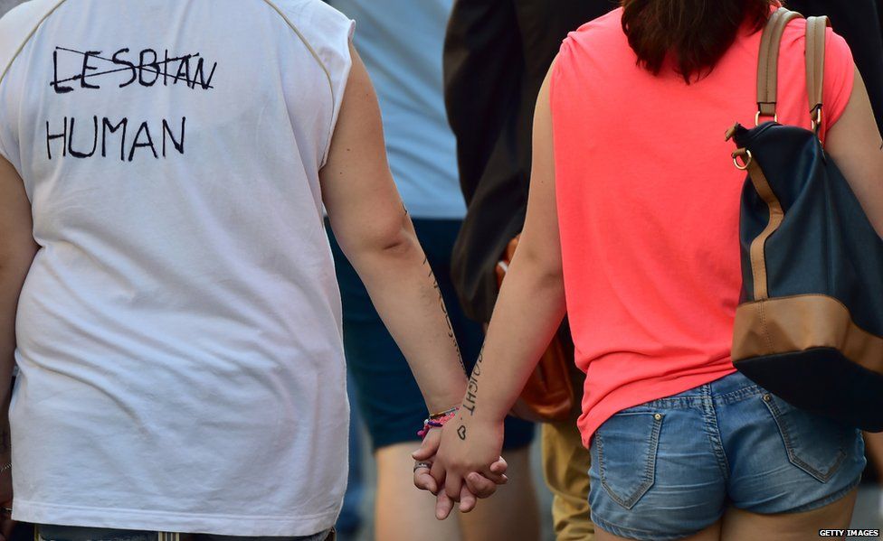 People hold hands as they take part in the annual Lesbian, Gay, Bisexual and Transgender (LGBT) Pride Parade in Milan, on 27 June 2015