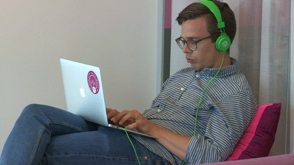 Man listening to music on his headphones from a laptop