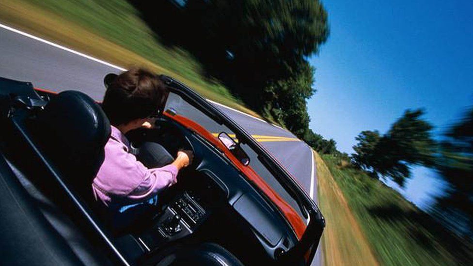 Man driving car with roof down
