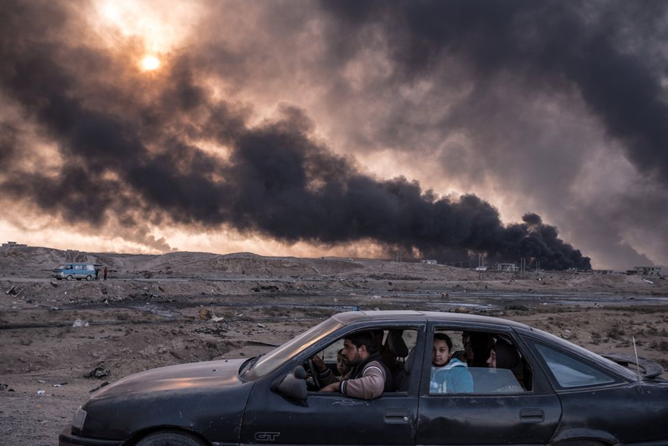 A family flees the fighting in Mosul, Iraq's second-largest city, as oil fields burned in Qayyara, Iraq, on 12 November 2016.