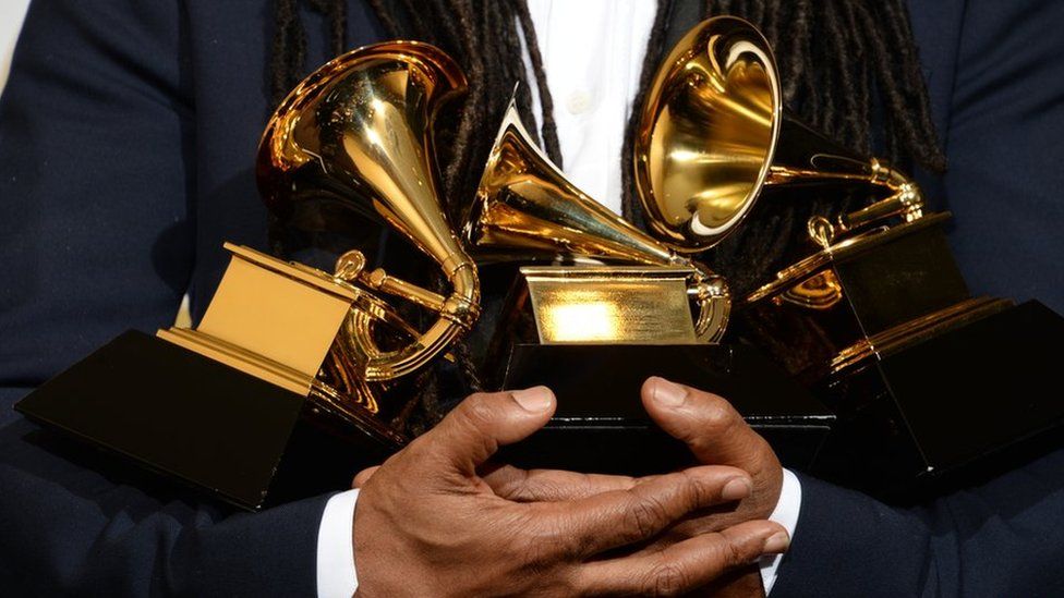Nile Rogers holding his Grammy Awards