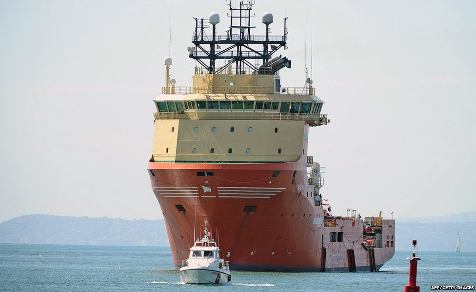 The Norwegian military ship Siem Pilot carries 416 rescued migrants and 49 bodies as they arrive at the Italian port of Catania on 17 August, 2015.