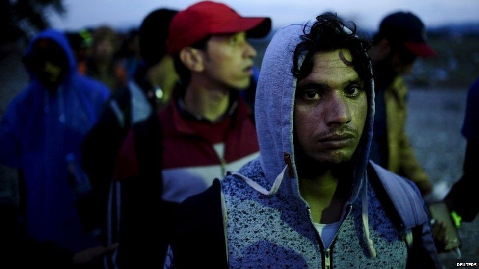 Migrants wait to enter a transit camp after entering the country by crossing the border with Greece