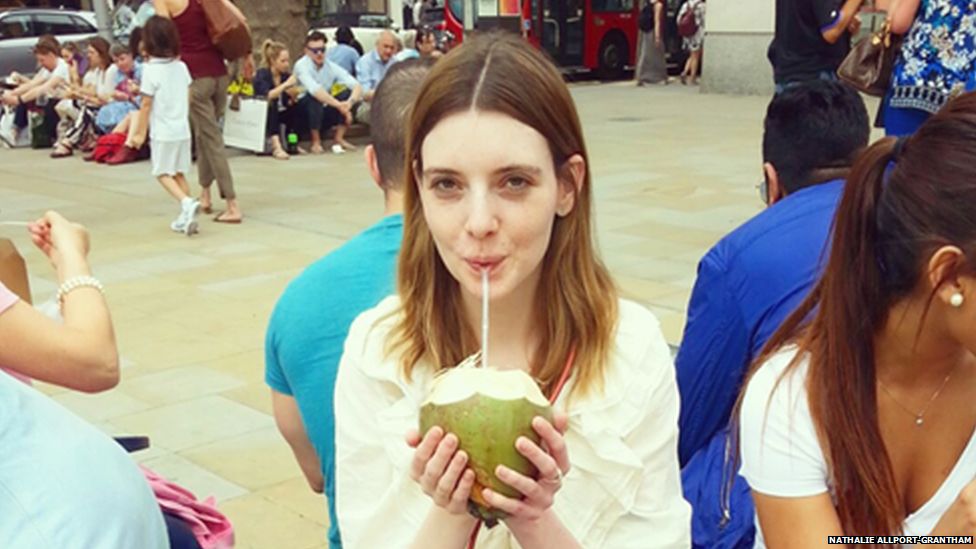 Nathalie drinking from a coconut
