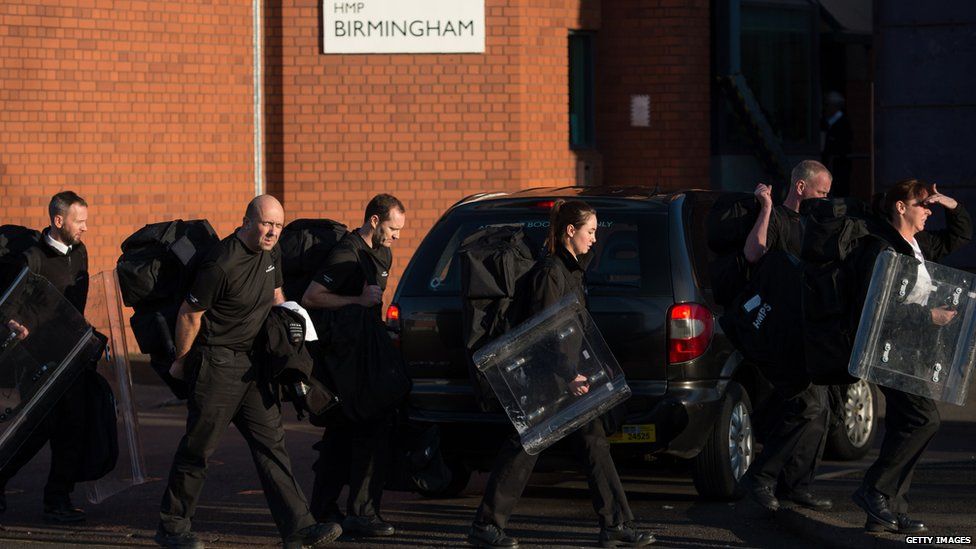 Prison staff carrying riot shields leave HMP Birmingham in Winson Green, Birmingham