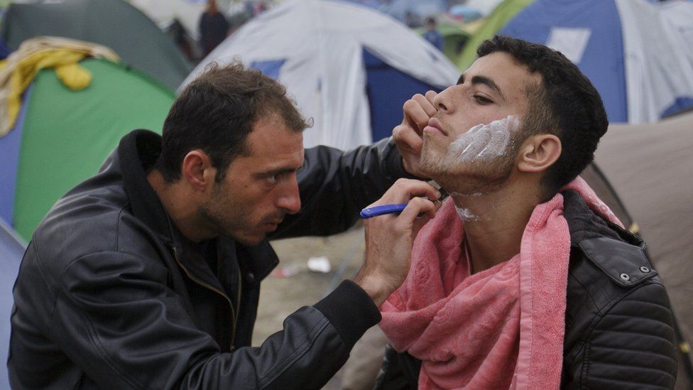 A barber shaves a migrant at the Idomeni camp (07 March 2016)