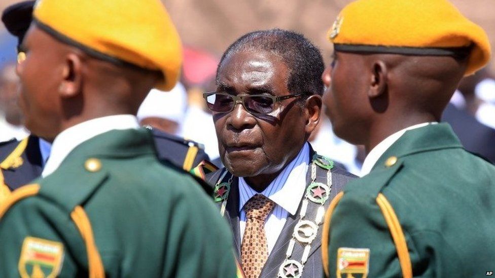 Zimbabwean President Robert Mugabe inspects the guard of honour during a ceremony in Harare, Monday Aug. 10, 2015, honouring thousands of fighters who died in a 1970s Bush war against colonialism.