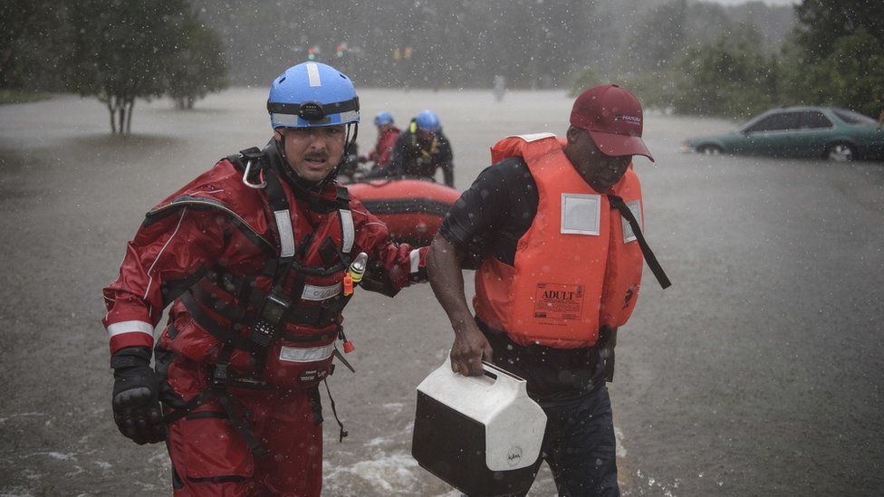 A water rescue team member leads Derrick Williams out of the water at the onramp of the MLK Freeway after rescuing Williams from the flood waters caused by Hurricane Matthew on Saturday, Oct. 8, 2016, in Fayetteville, N.C