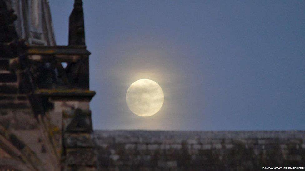 A bright full moon by a church