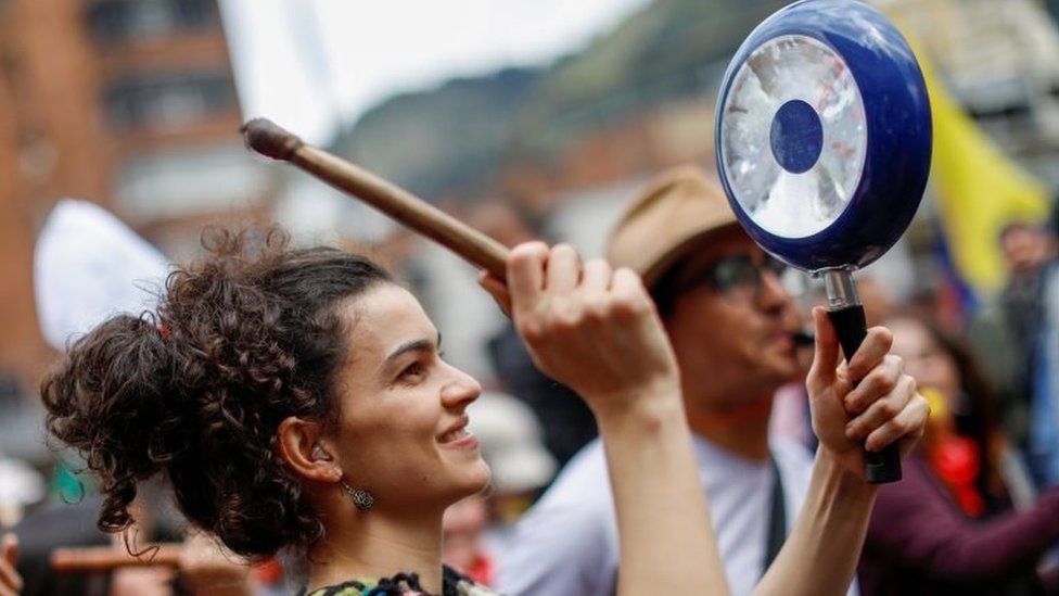 A woman hits a pan during a protest in Bogota on 27 November 2019