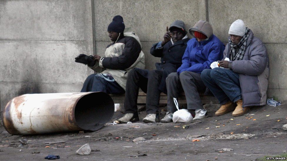 Four young men sitting on a bench