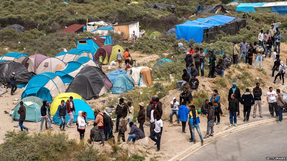 Many people surrounding tents
