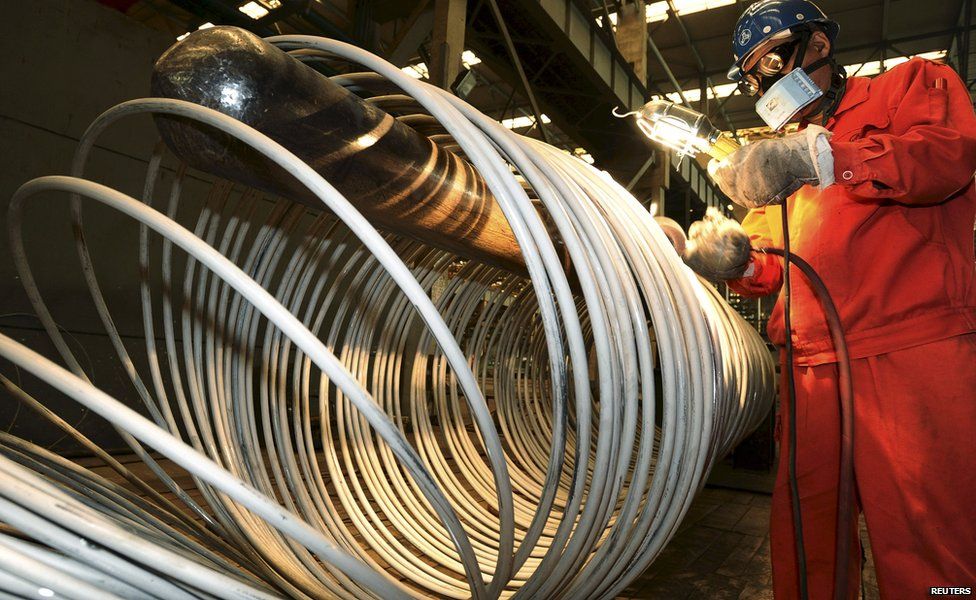 A worker polishes steel coils at a factory in Dalian, China