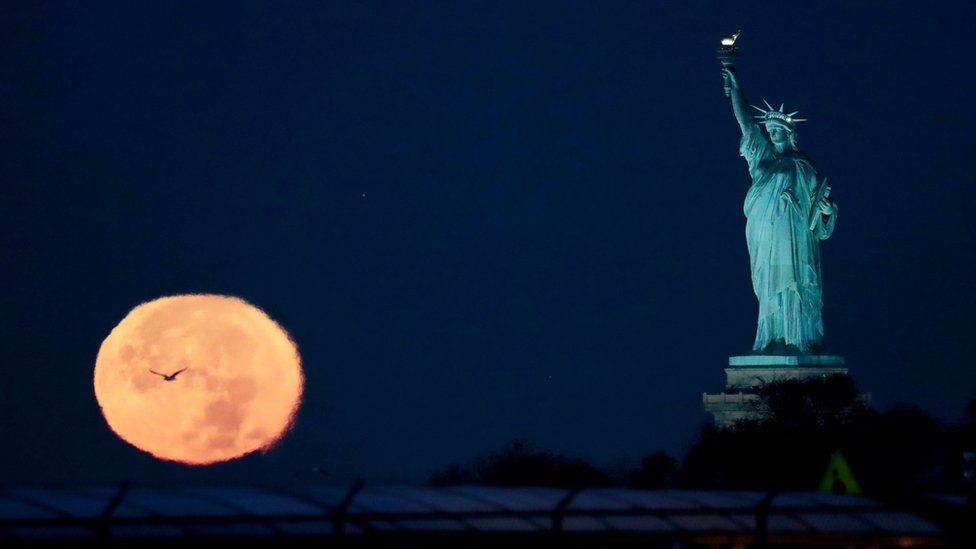 The supermoon appears near the Statue of Liberty, Monday, Nov. 14, 2016, in New Yor