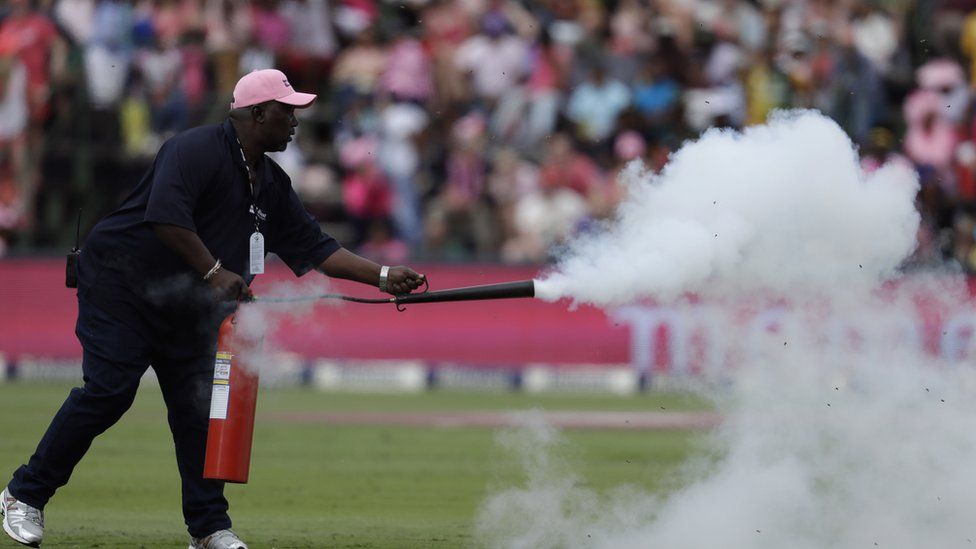 Buthuel Buthelezi, head grounds man, sprays bees on a cricket pitch with a fire extinguisher at the Wanderers stadium in Johannesburg, South Africa, Saturday 4 February 2017