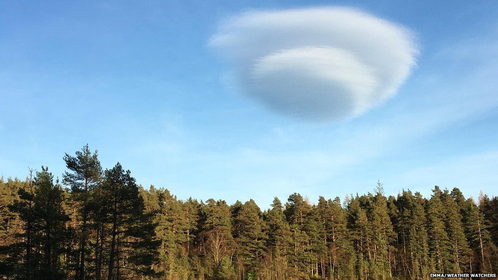 Lens shaped clouds above a forest