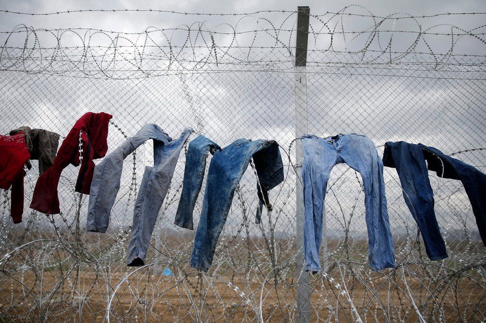 Refugees dry clothes on the barbed