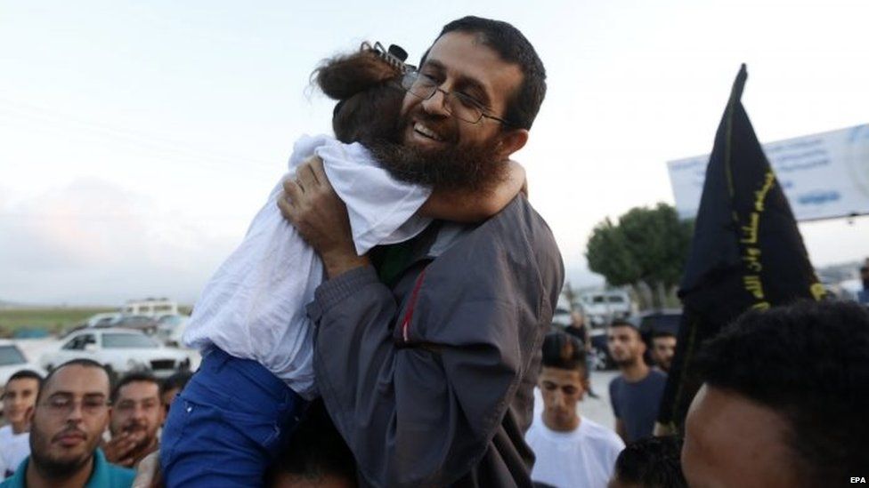 Khader Adnan hugs his daughter as he arrives home in the village of Araba, near the West Bank City of Jenin, 12 July 2015