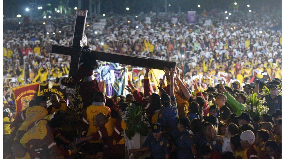 Thousands of Filipino devotees carry the statue of the Black Nazarene during the annual religious procession in Manila. 9 January 2017.