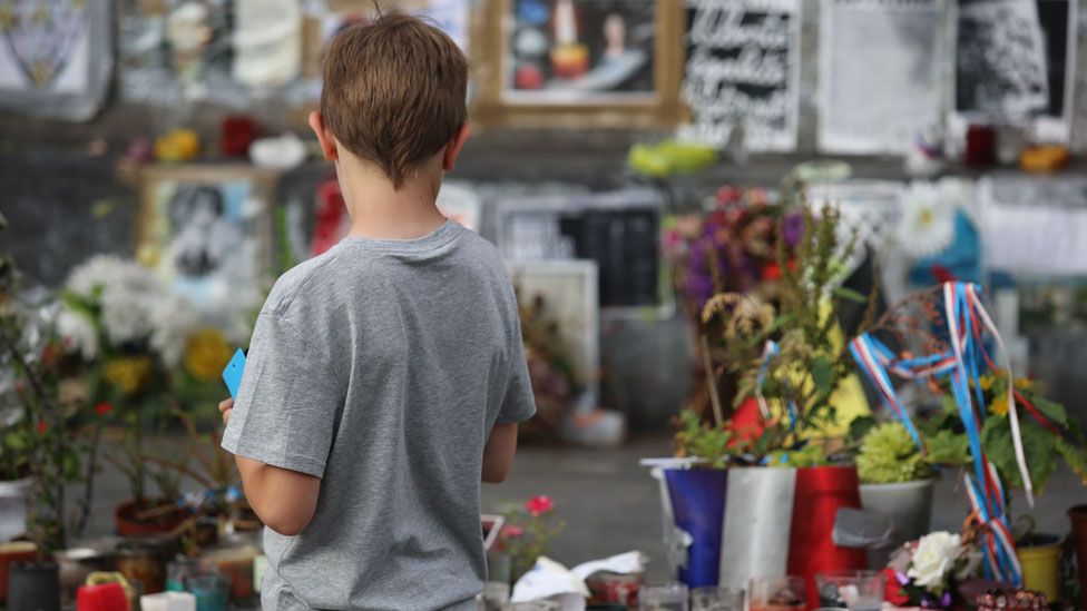 Young boy looks at a memorial