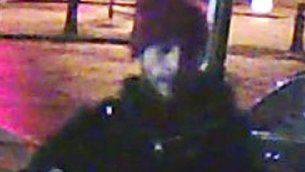 CCTV image of a man with a read hat on