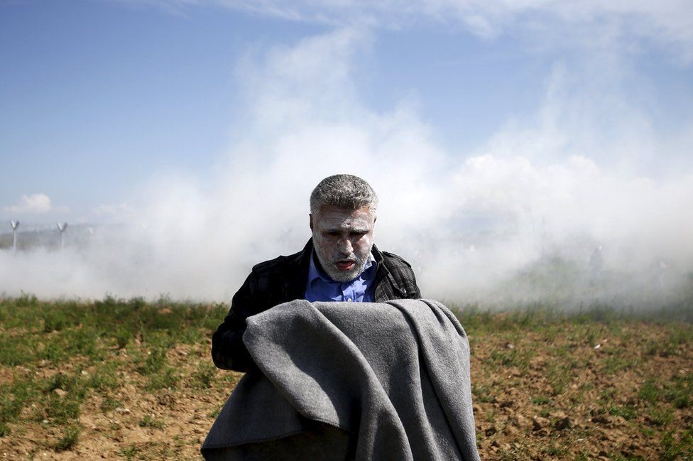 Ένας μετανάστης πιάνει την ανάσα του, μετά την εισπνοή δακρυγόνων