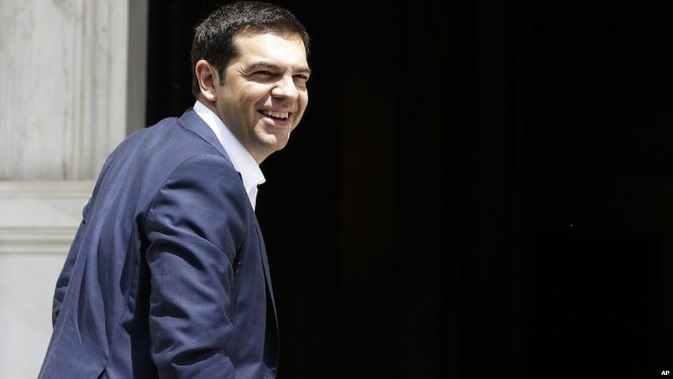 Greece's Prime Minister Alexis Tsipras smiles as he arrives at Maximos Mansion in Athens on Tuesday, June 23, 2015