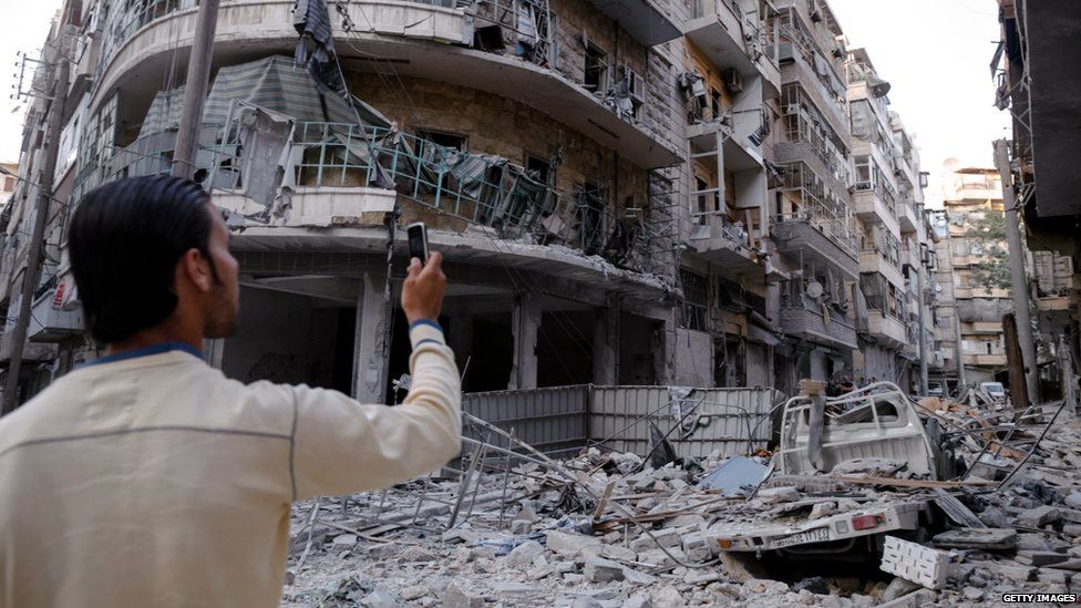 Man taking a photo of rubble