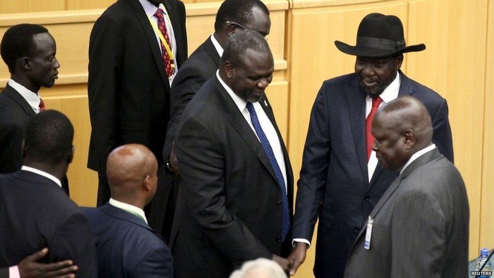South Sudan rebel leader Riek Machar (centre) shakes hand with South Sudan President Salva Kiir (in black hat) at a peace summit attended 17/08/2015