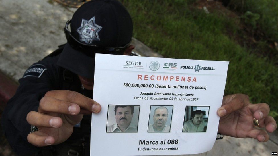 A police officer shows a reward notice as investigators and members of Federal Police continue investigations into the escape of drug trafficker Joaquin "El Chapo" Guzman, in Amolaya, Mexico, 16 July 2015.