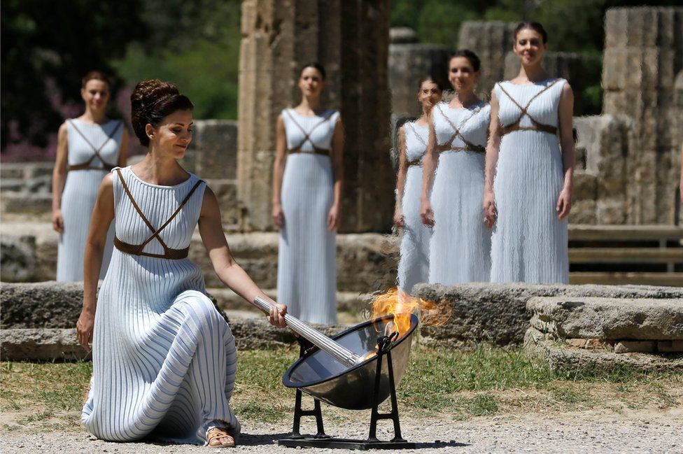 Greek actress Katerina Lehou, playing the role of High Priestess, lights the torch