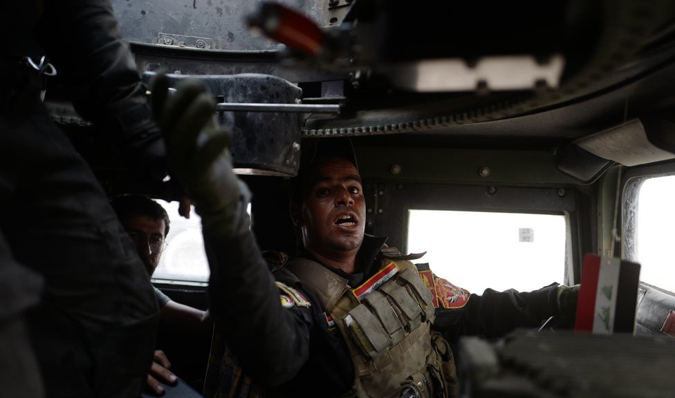 A Golden Division soldier passes ammunition up to his Humvee's gunner during the battle for Bazwaya (24 October 2016)