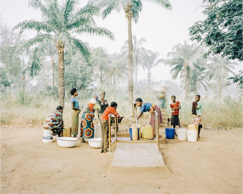 Women and children collect drinking water from a well in Osukputu, Benue, Nigeria