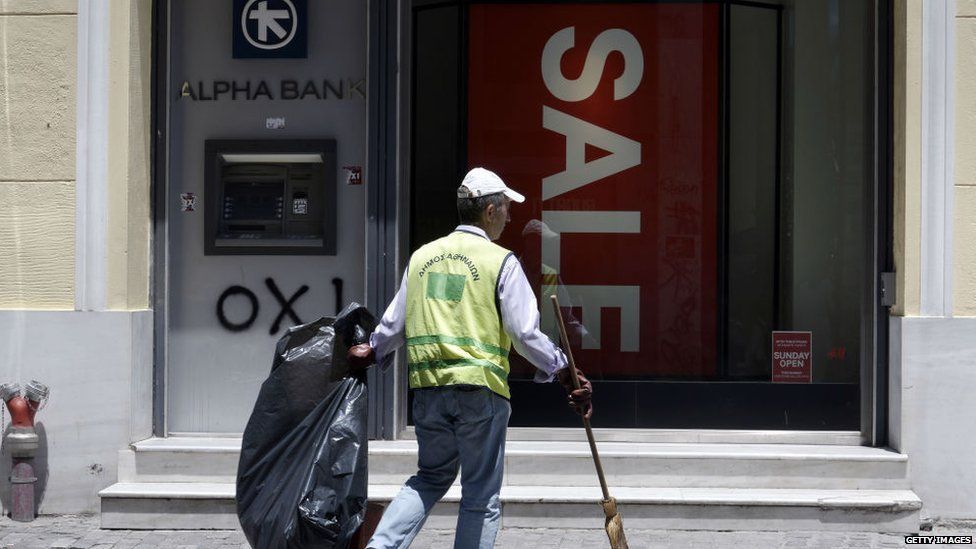 Street cleaner outside a shop and bank ATM in Athens, on 13 July 2015