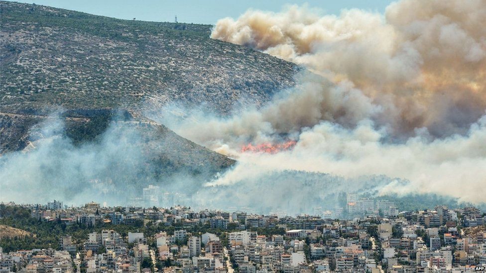Smoke and flames billow over Athens on 17 July 2015
